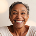 A photo of a woman in her 50s smiling and looking happy.